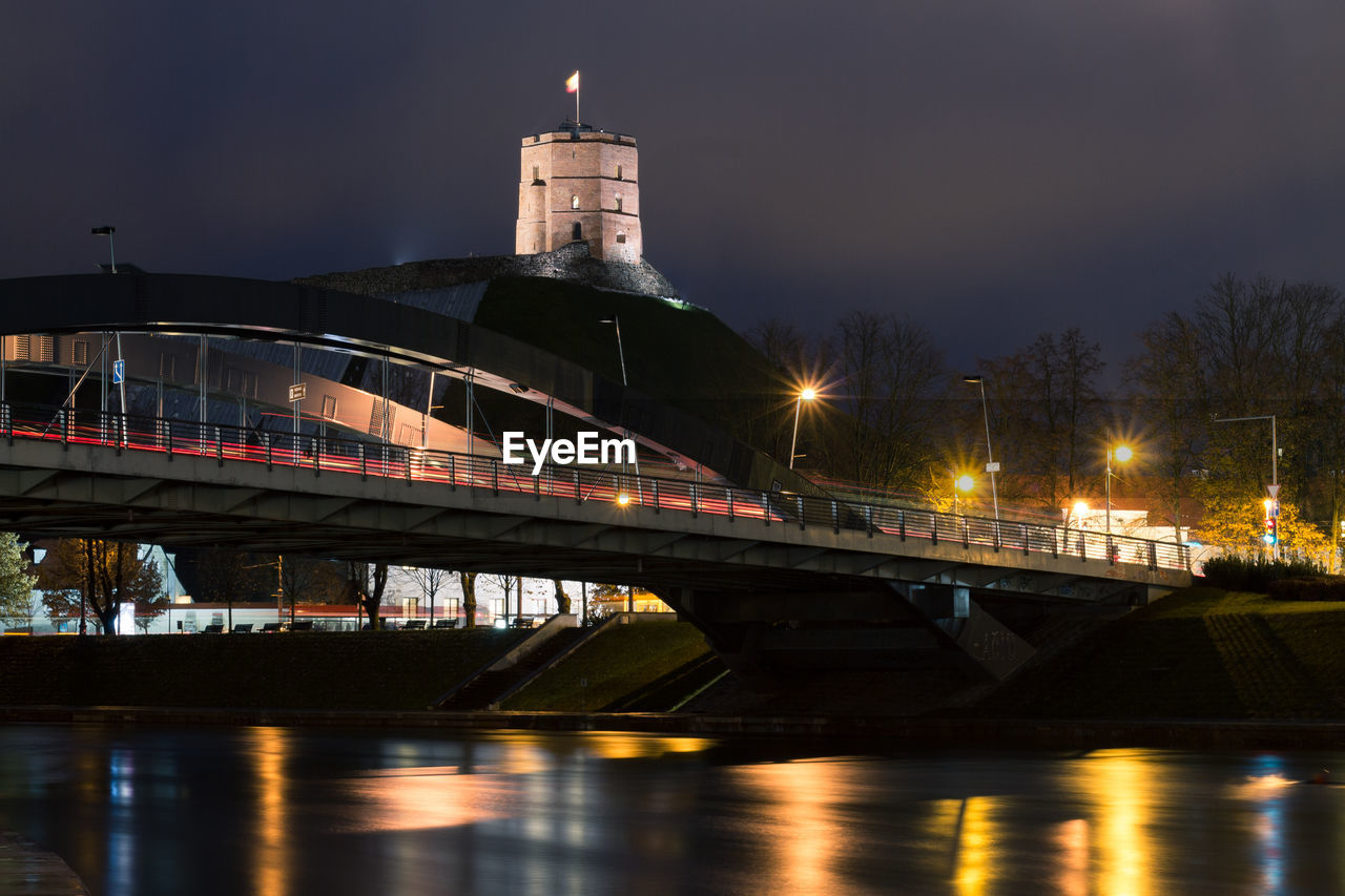 View of bridge over river at night