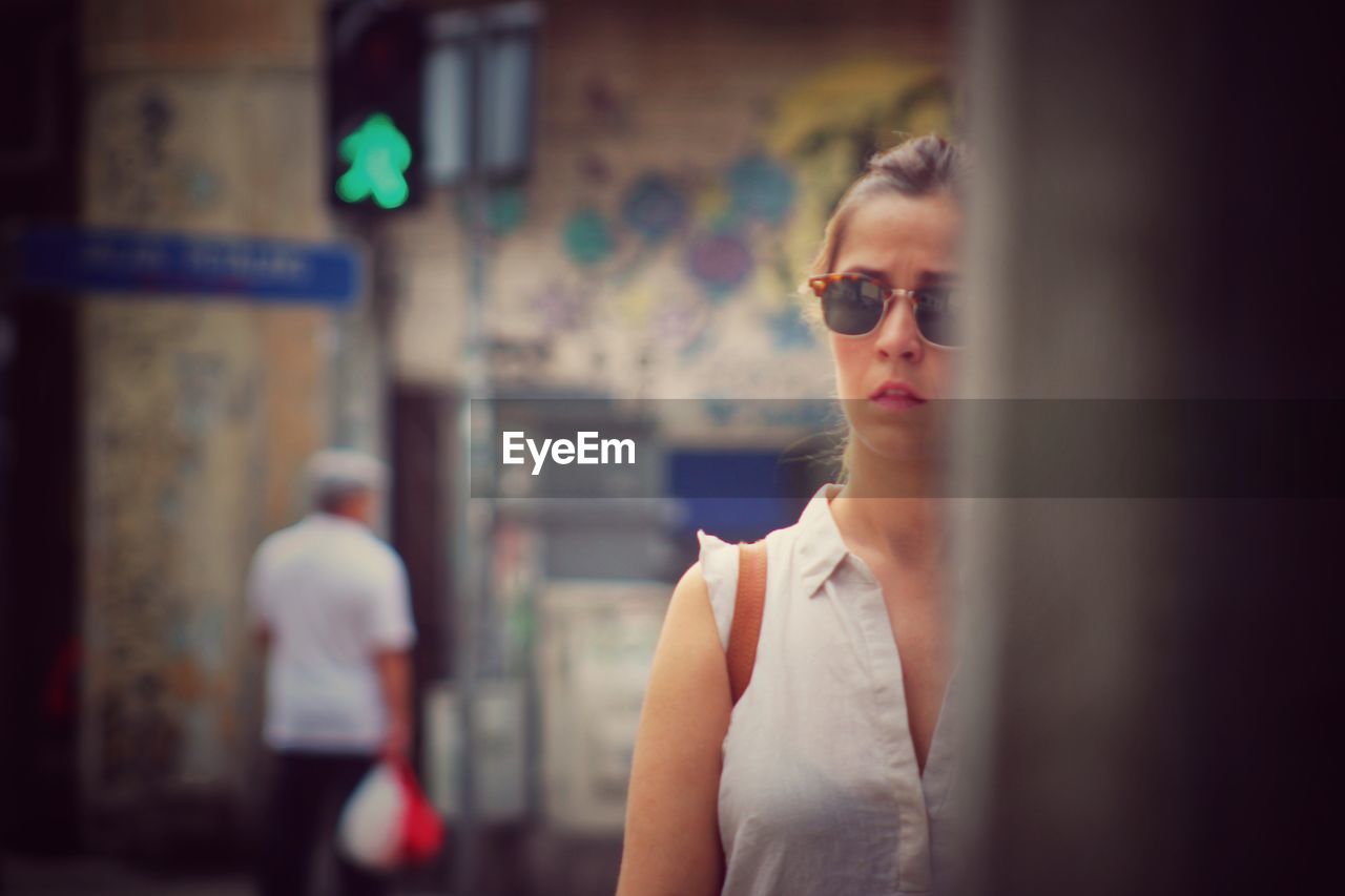 Young woman wearing sunglasses while standing on city street