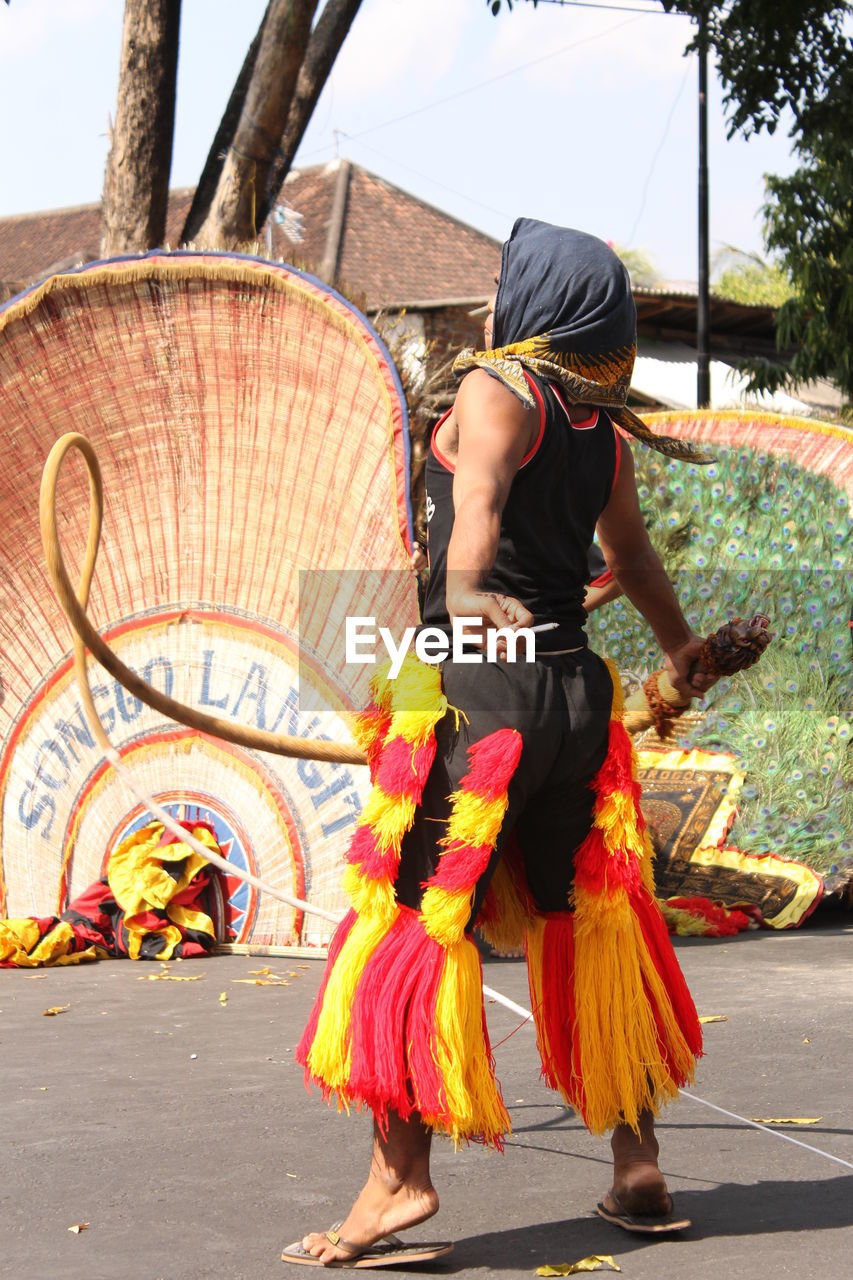 FULL LENGTH REAR VIEW OF WOMAN DANCING IN TRADITIONAL CLOTHING