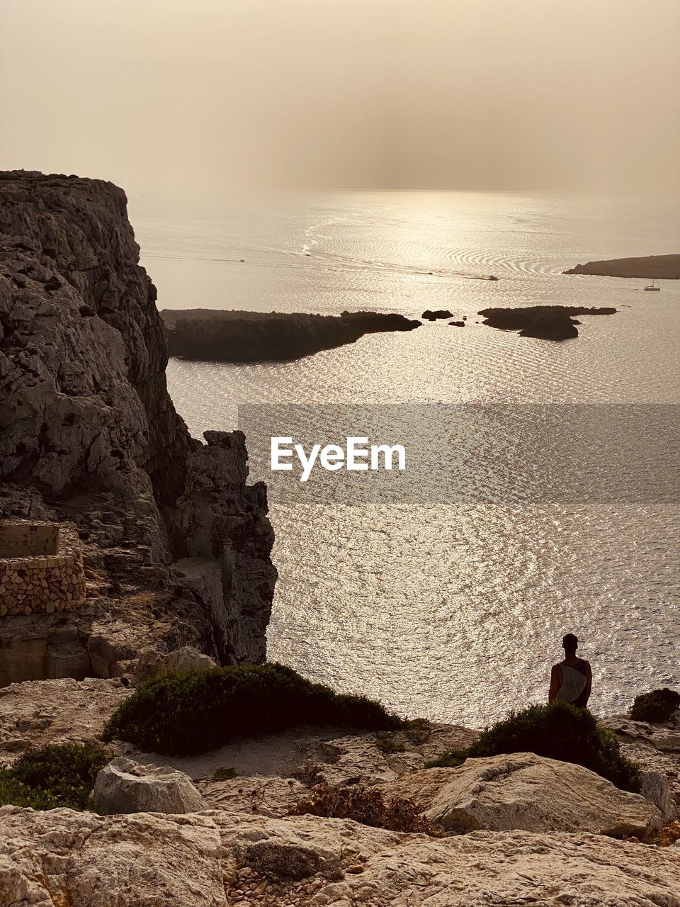 MAN LOOKING AT SEA SHORE