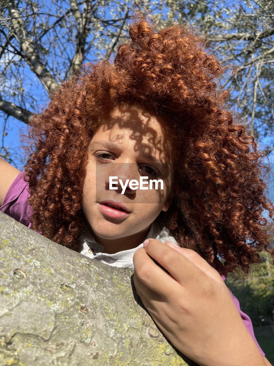 one person, young adult, adult, nature, tree, women, leisure activity, spring, human hair, portrait, plant, day, person, lifestyles, sunlight, relaxation, lying down, hairstyle, headshot, smiling, human face, brown hair, curly hair, outdoors, emotion, clothing, eyes closed, sky, hand, female, happiness, front view, casual clothing, human head