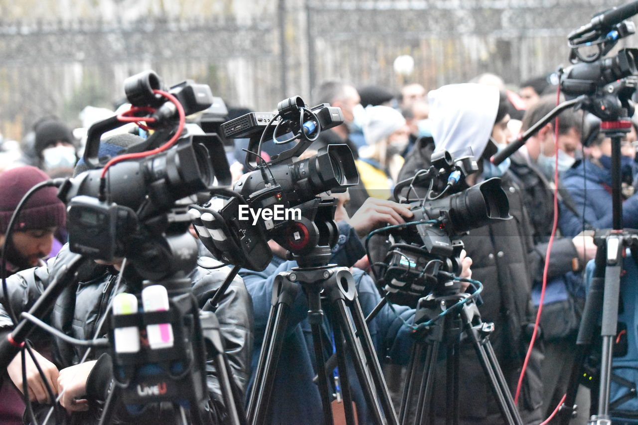 Close-up of cameras with crowd in background