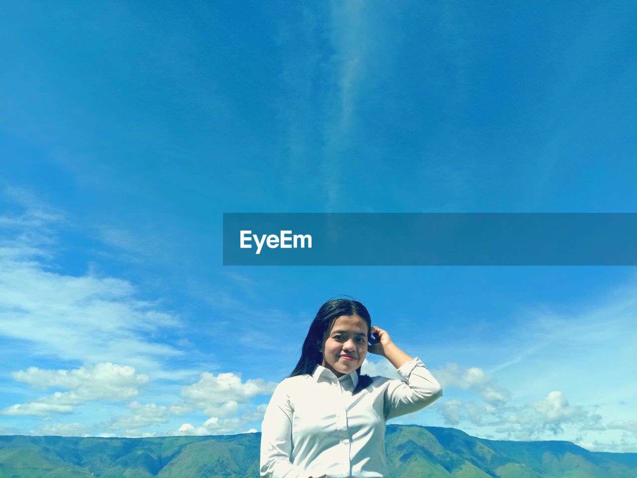 Portrait of young woman against blue sky