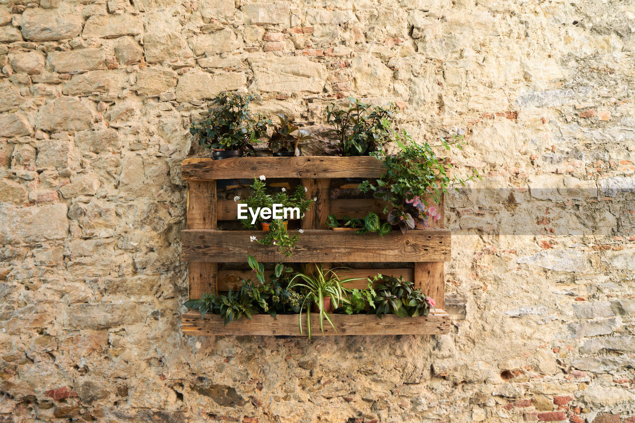 Pallet flower planter on a rustic brick wall