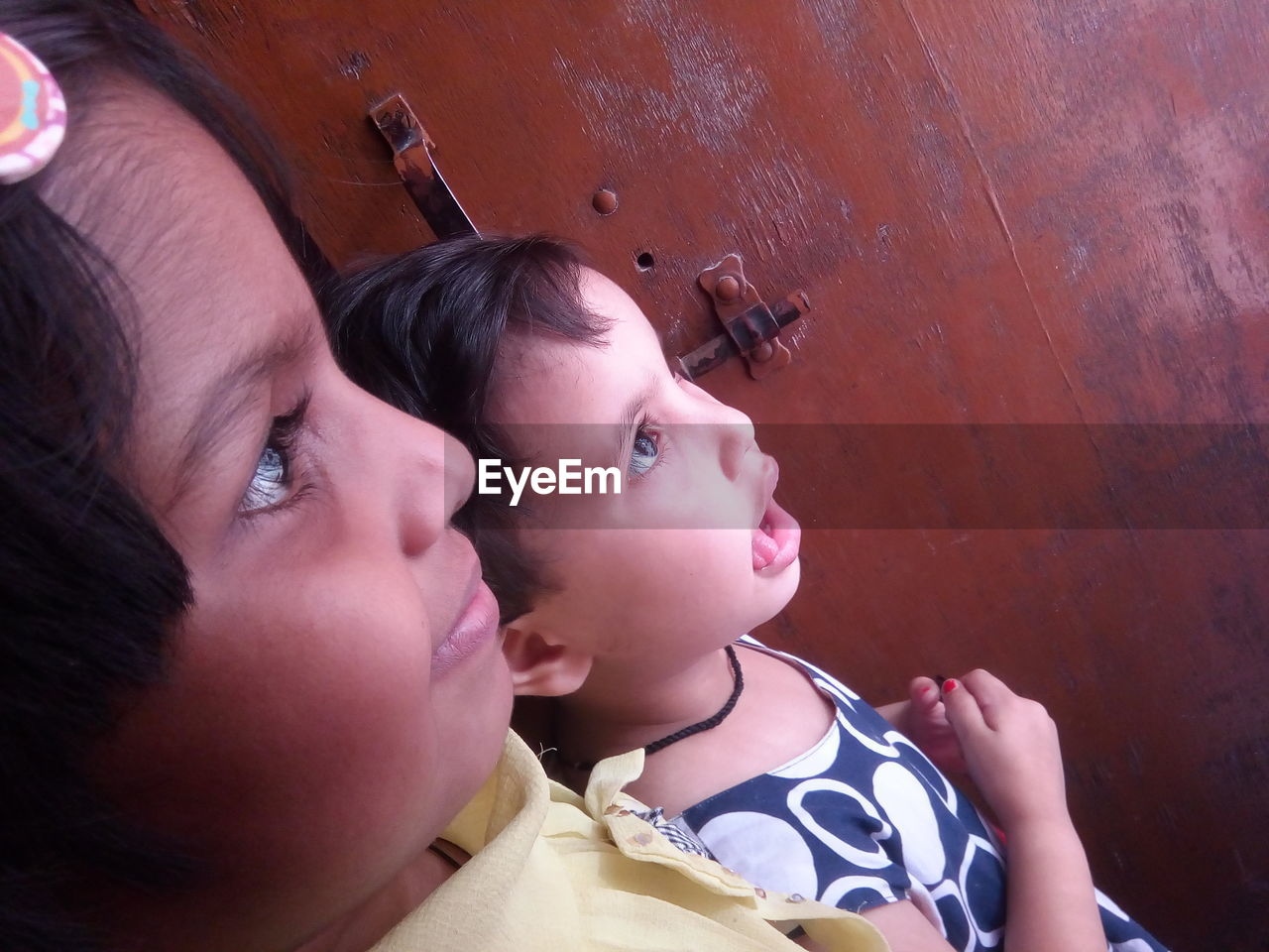 Side view of siblings looking away at home