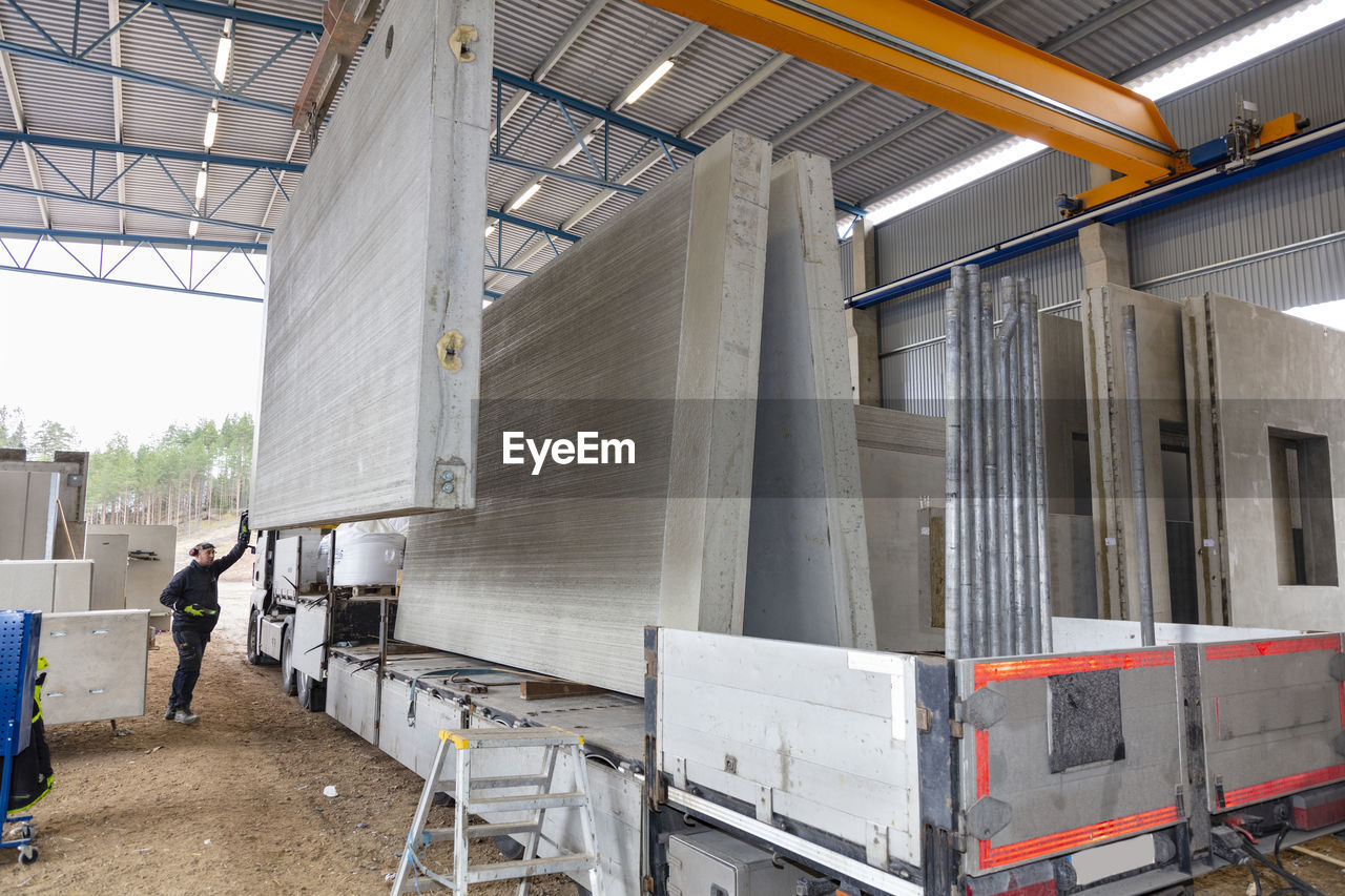 Worker sorting concrete segments in warehouse