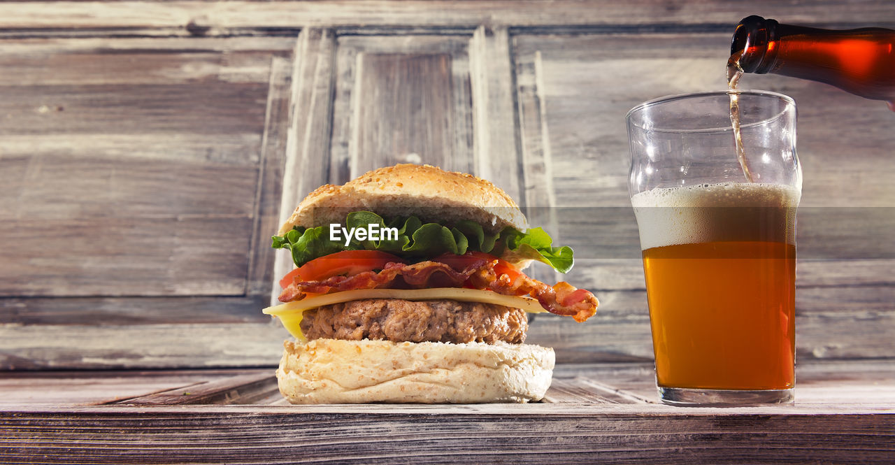 Close-up of burger and drink served on table