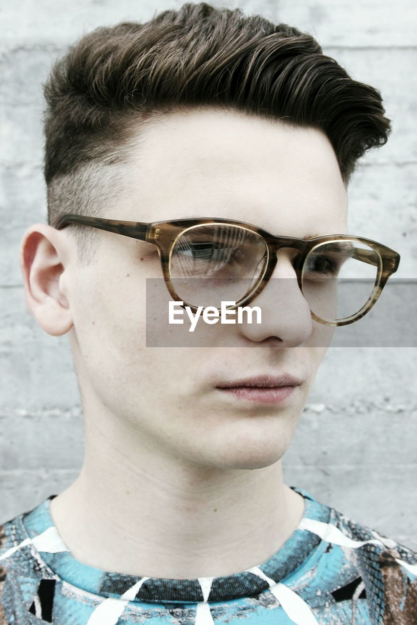 CLOSE-UP PORTRAIT OF YOUNG MAN WEARING SUNGLASSES