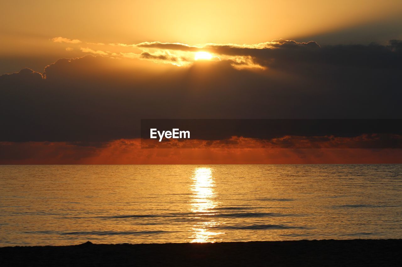 SUN SHINING OVER SEA DURING SUNSET