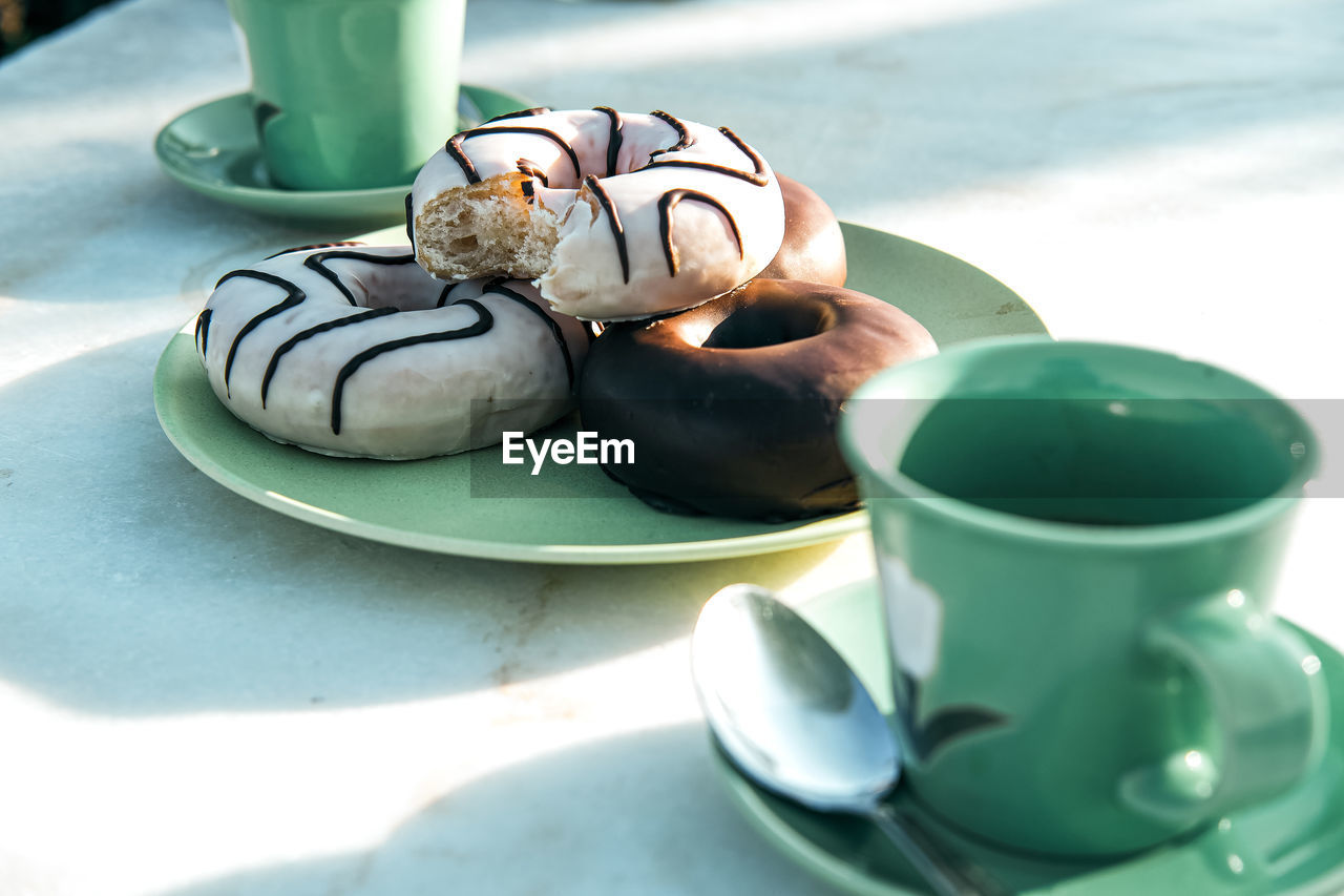 Composition of aromatic hot drink and tasty donuts on table