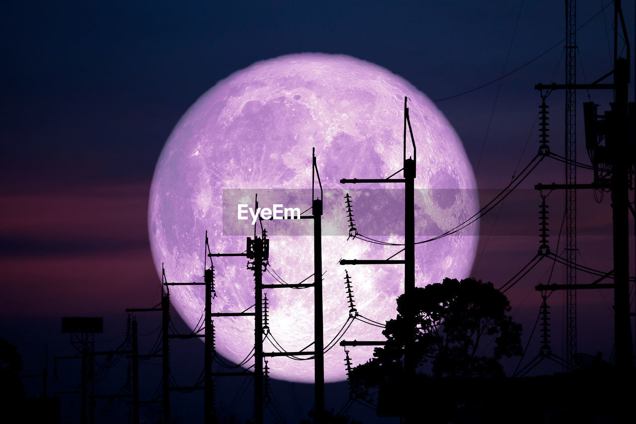 LOW ANGLE VIEW OF TELEPHONE POLE AGAINST SKY AT DUSK