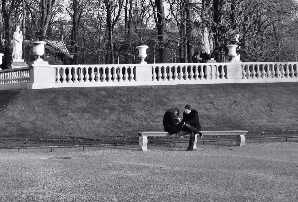 WOMAN SITTING ON PARK BENCH