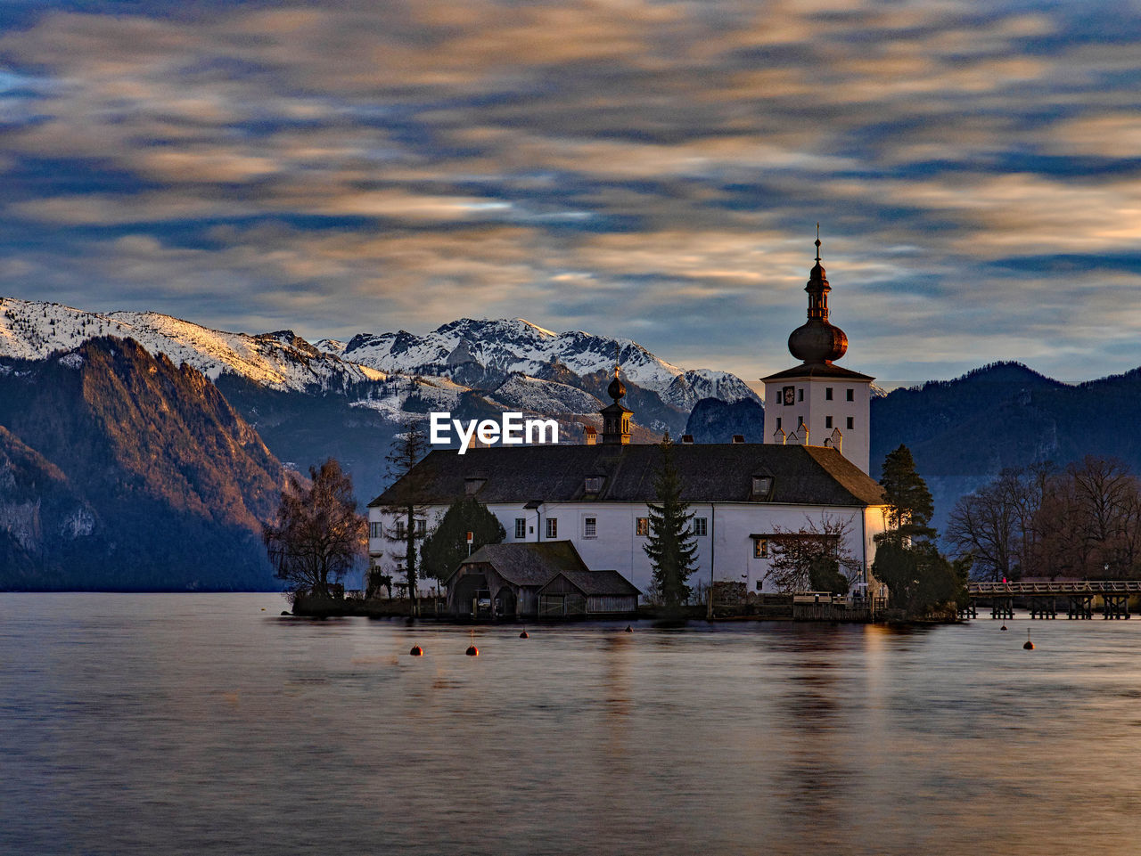 BUILDINGS BY MOUNTAIN AGAINST SKY DURING WINTER