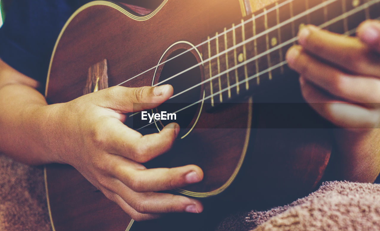 Cropped hands of man playing guitar