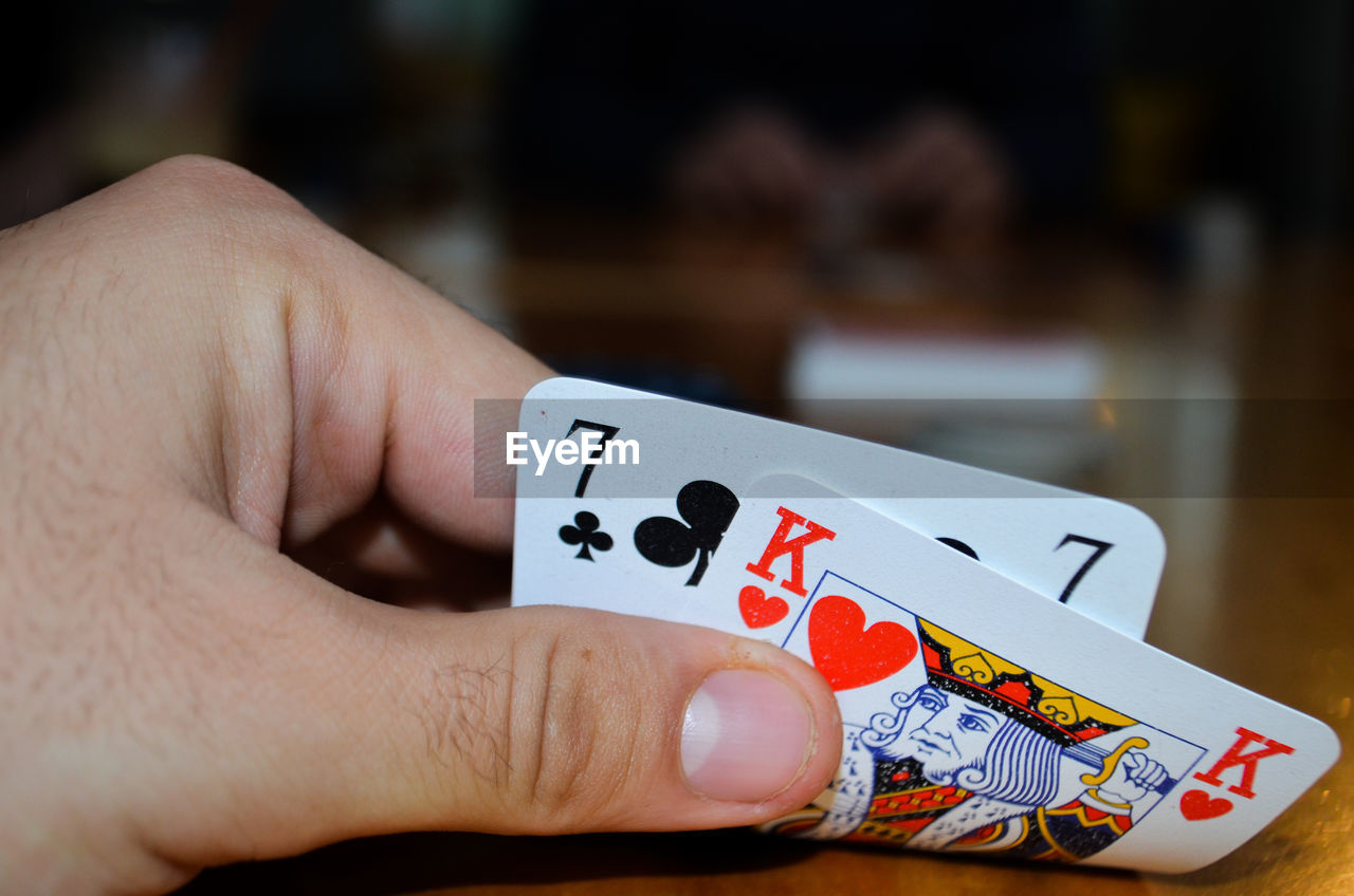 Cropped hand of man holding playing cards