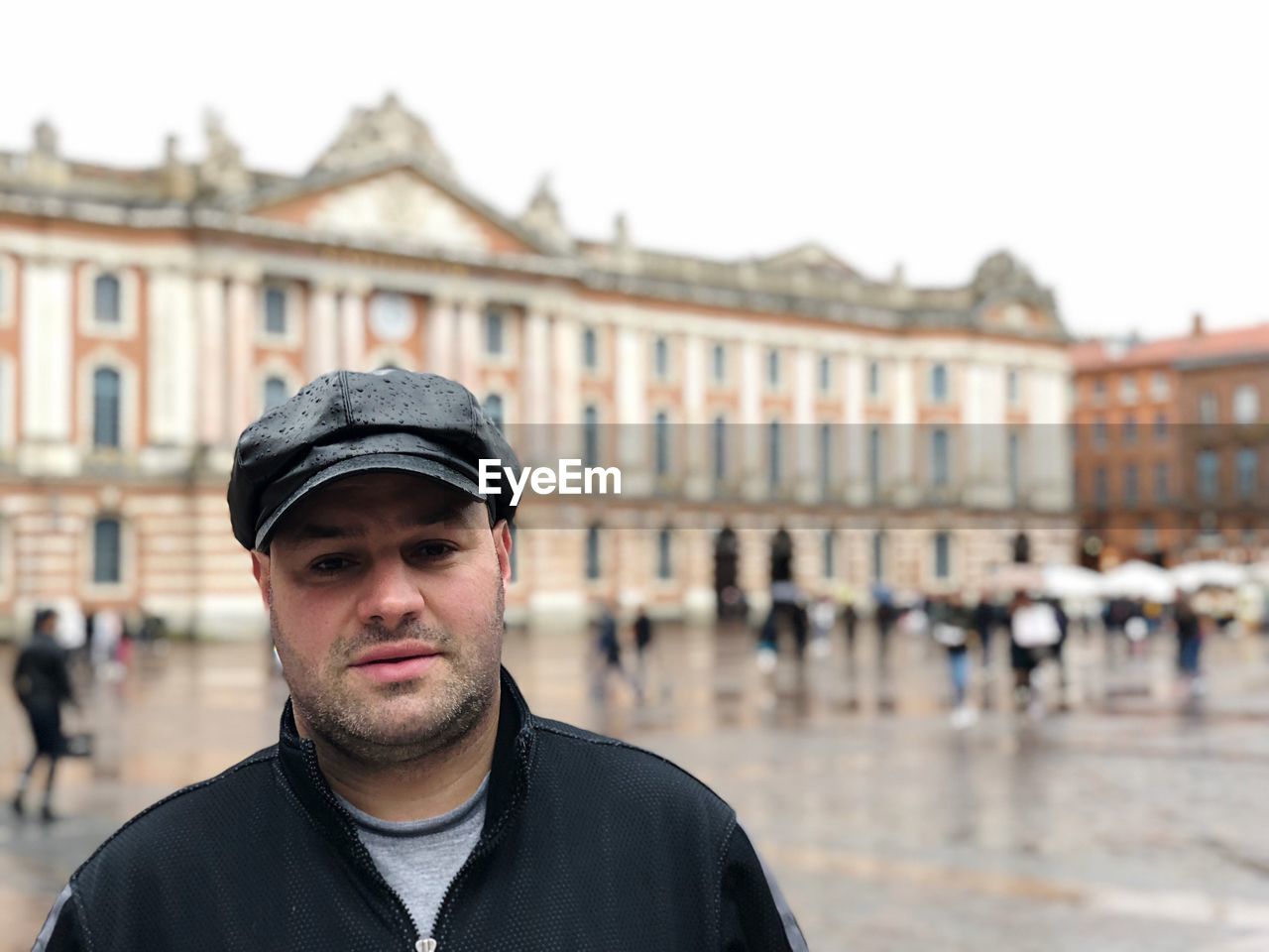 Portrait of man standing against buildings in city