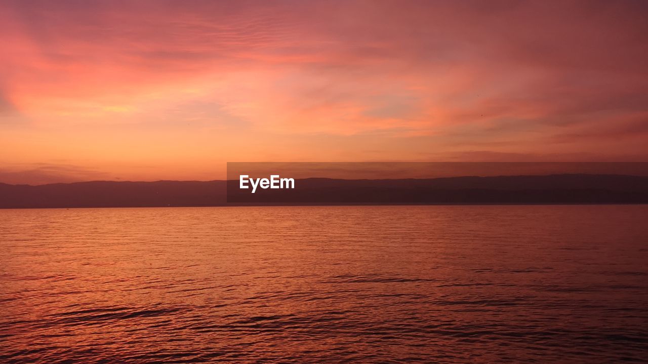 Scenic view of sea against orange sky