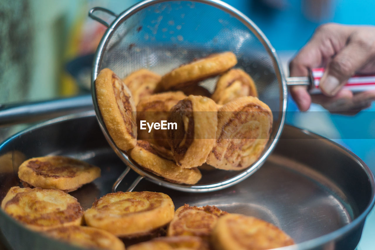 CLOSE-UP OF HAND HOLDING FOOD