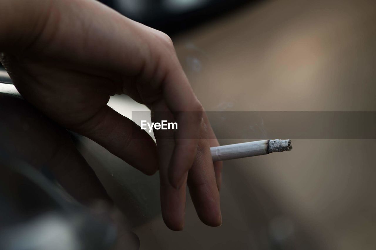 Close-up of hand holding cigarette