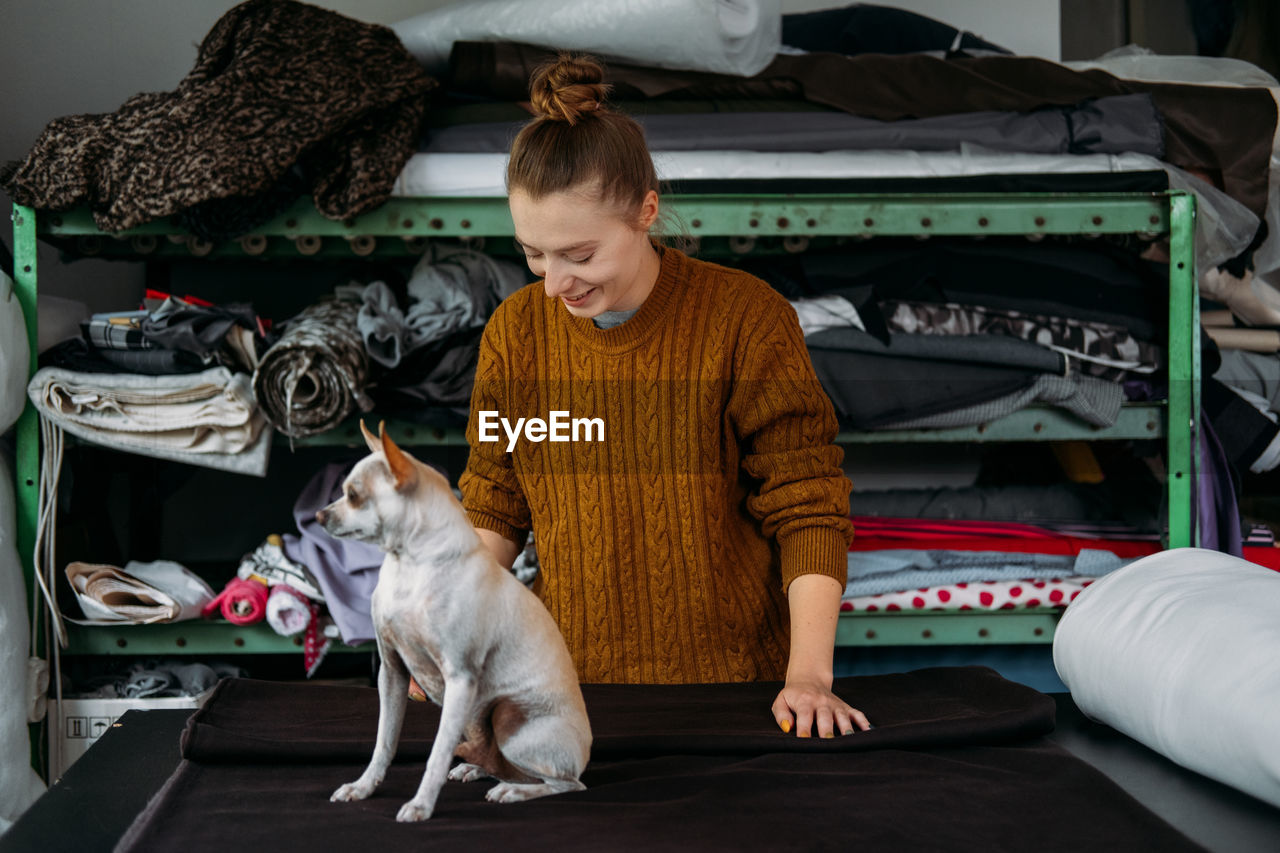 Woman and dog standing in garment factory