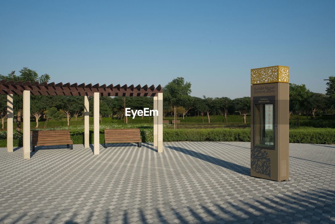 sky, architecture, nature, outdoor structure, clear sky, no people, plant, sunny, built structure, gate, blue, estate, tree, footpath, walkway, day, outdoors, entrance, sunlight, city