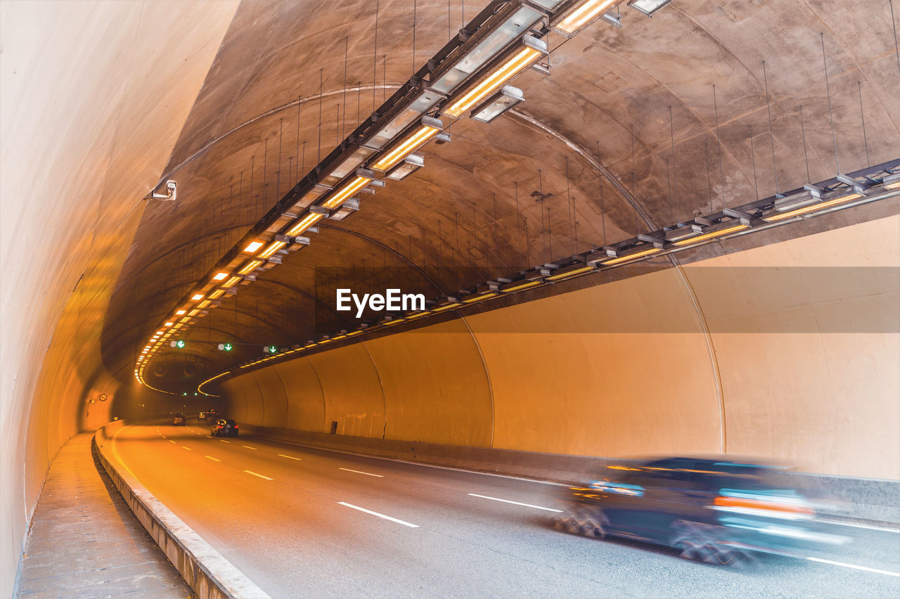 A car driving through a concrete tunnel