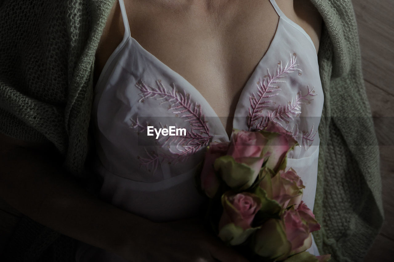 Midsection of woman holding rose bouquet