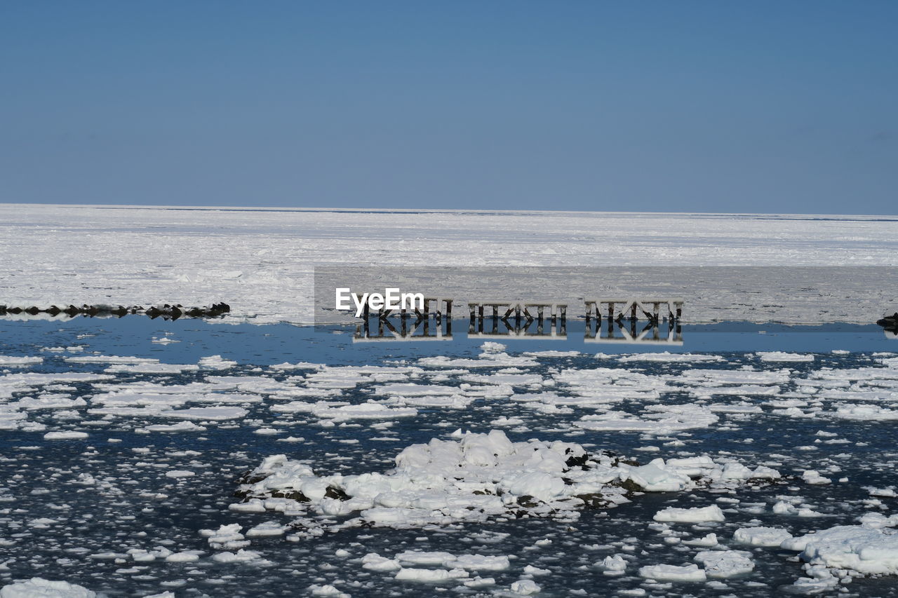 Scenic view of snowcapped seas against clear sky