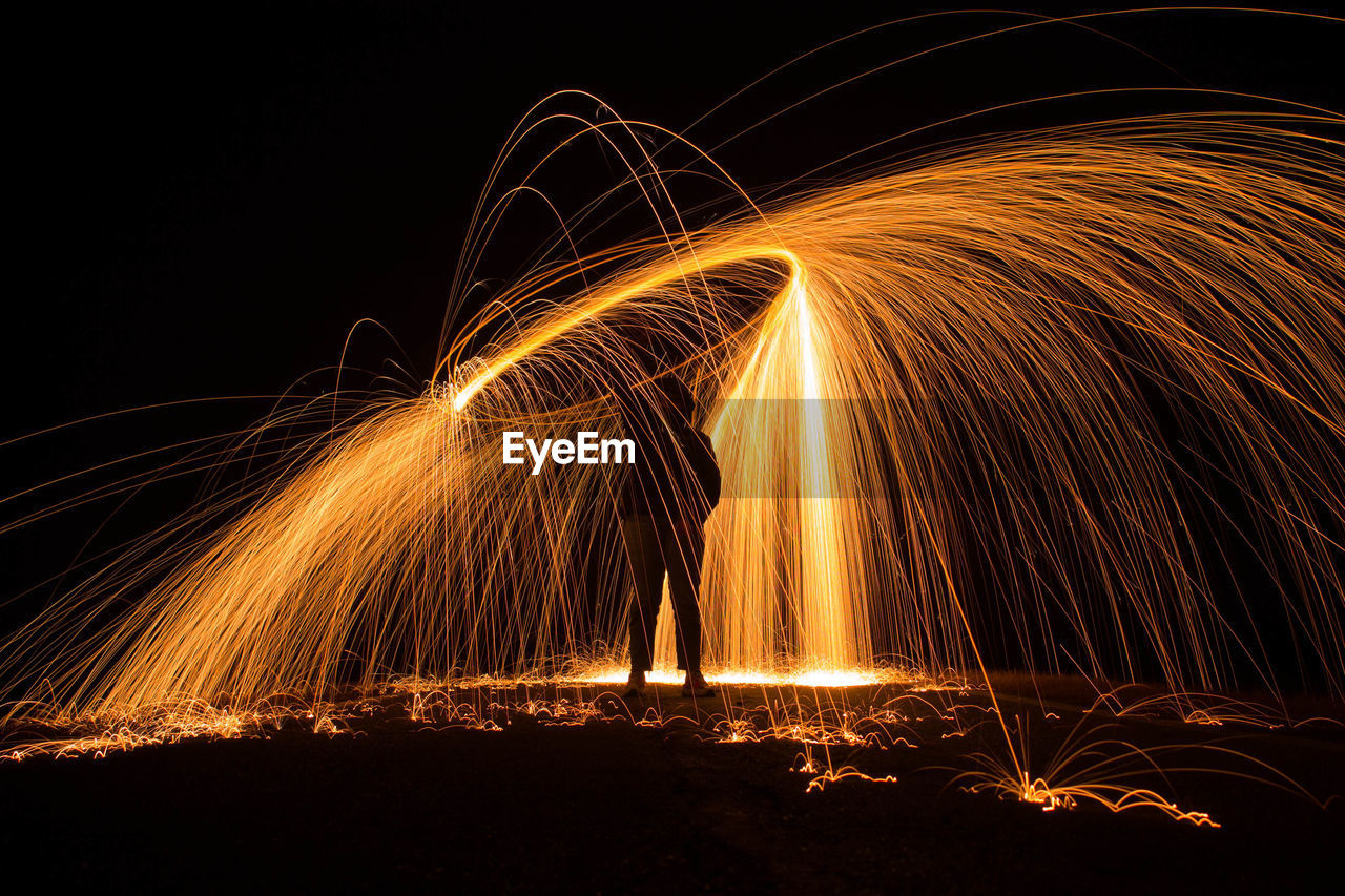 Woman spinning wire wool at night