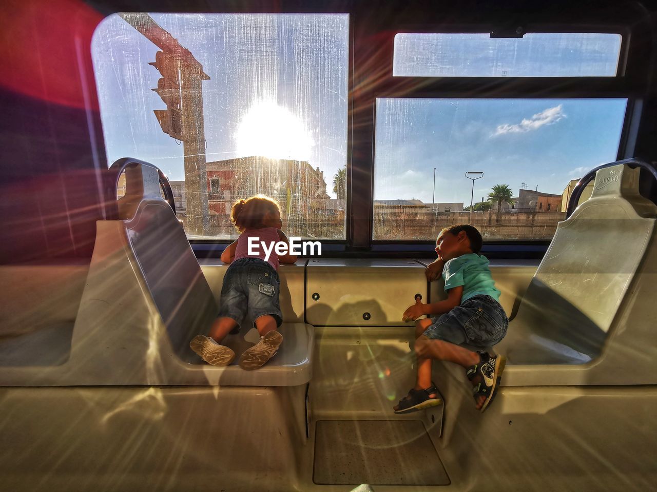 Rear view of people sitting on glass window