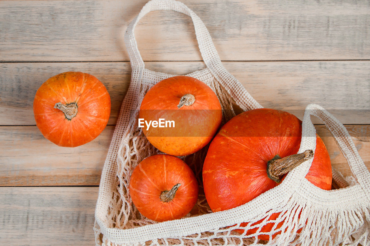 food and drink, food, healthy eating, wood, wellbeing, freshness, vegetable, produce, fruit, orange color, no people, basket, container, still life, pumpkin, high angle view, studio shot, indoors, plant, rustic, organic, agriculture, table, group of objects, autumn