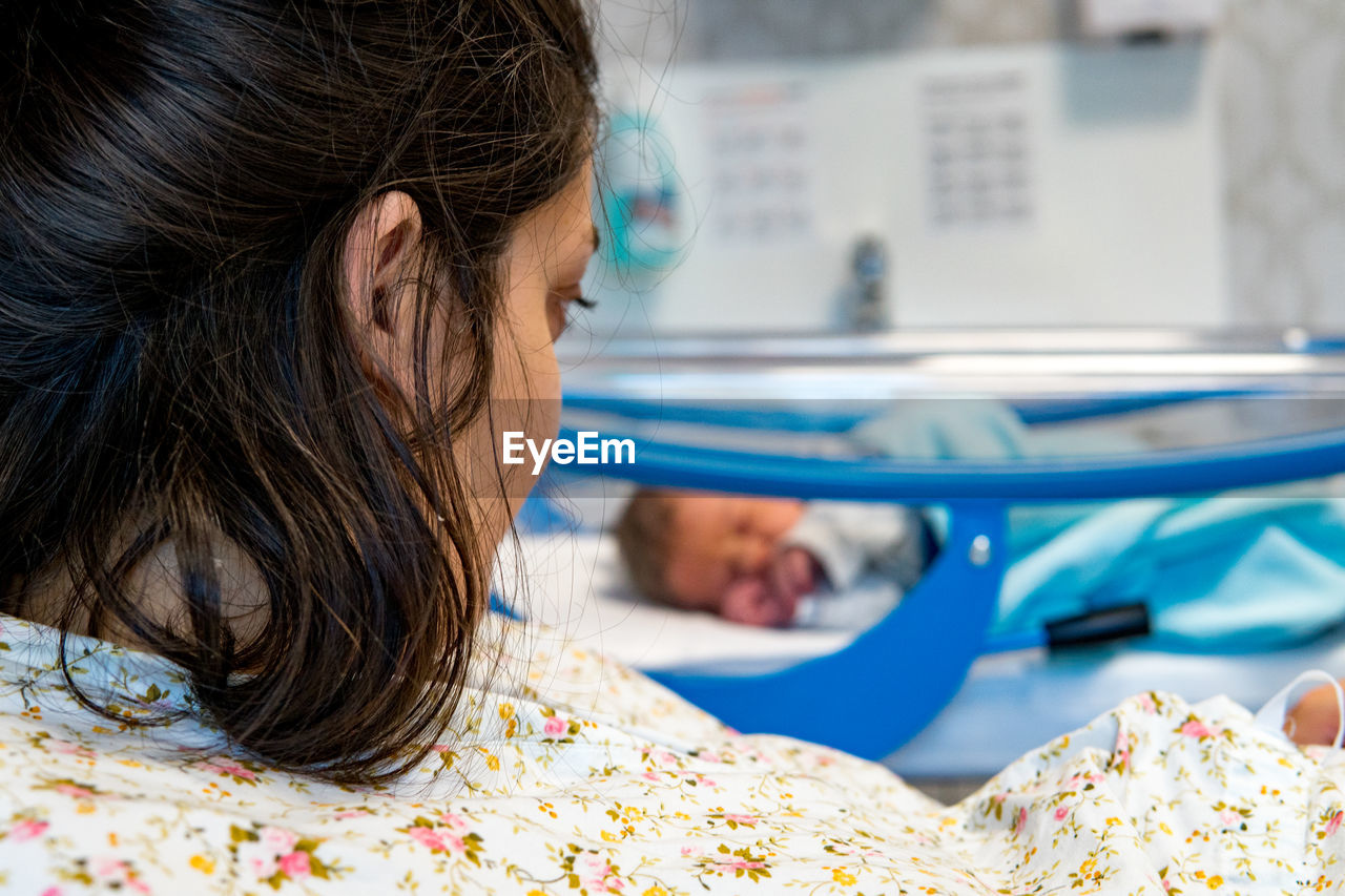 Mother looking at newborn baby at hospital