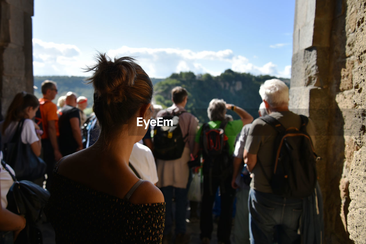 Rear view of people standing against sky