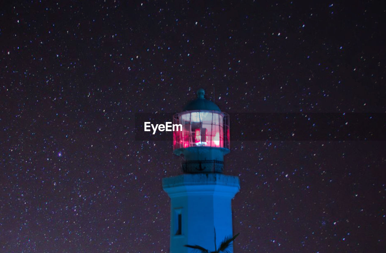 LOW ANGLE VIEW OF ILLUMINATED LIGHTHOUSE AGAINST SKY