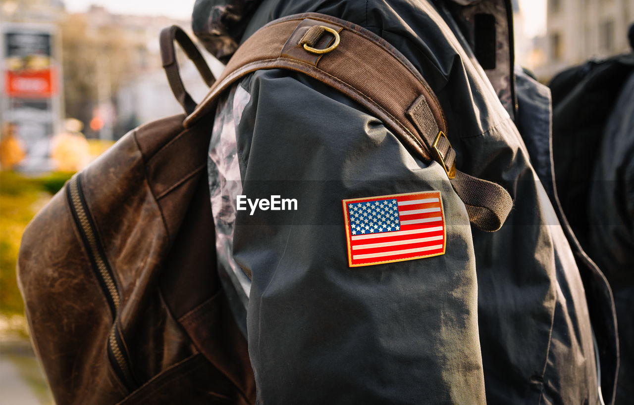 Person with backpack and jacket with flag of the united stats of america