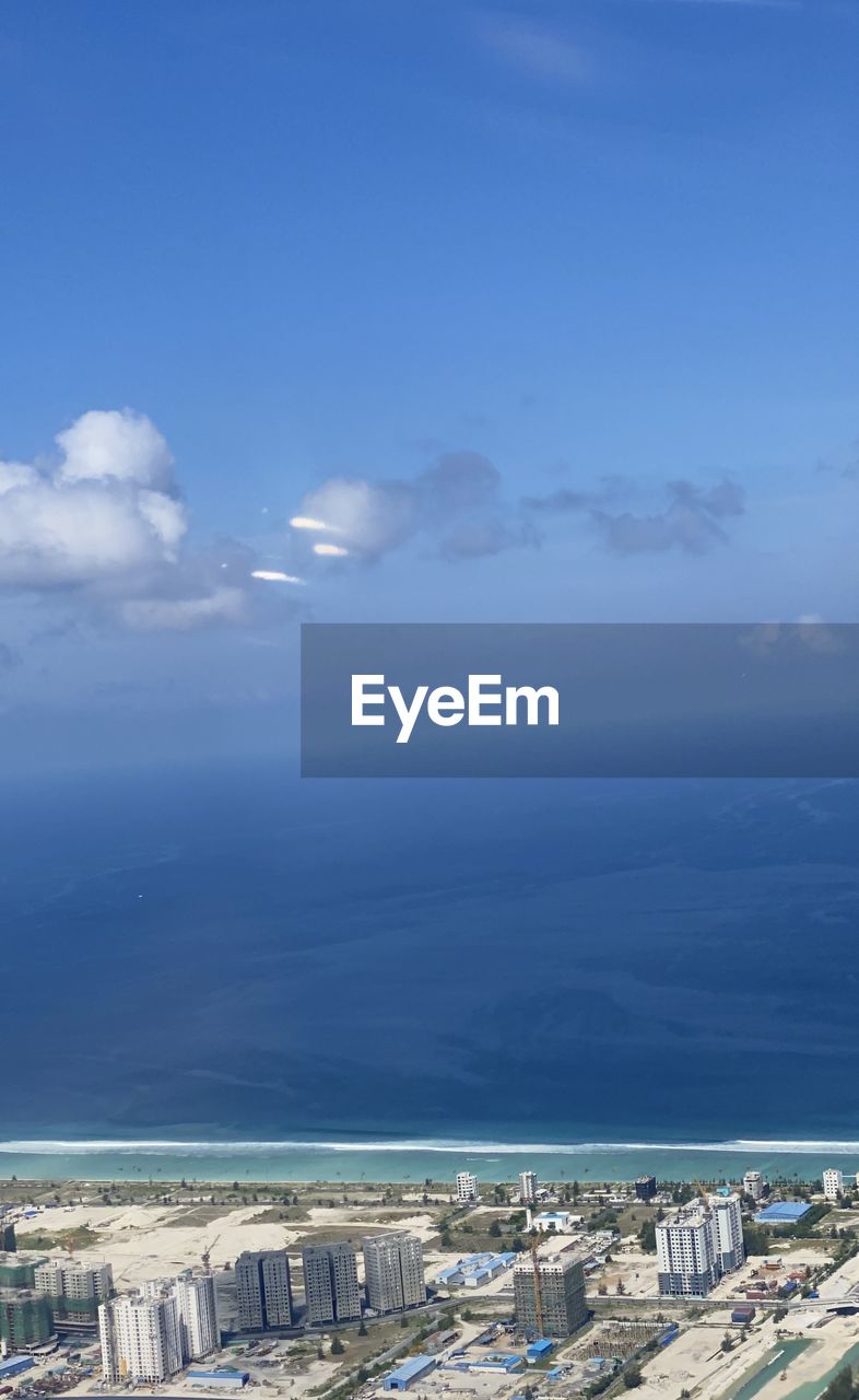 High angle view of sea and buildings against sky