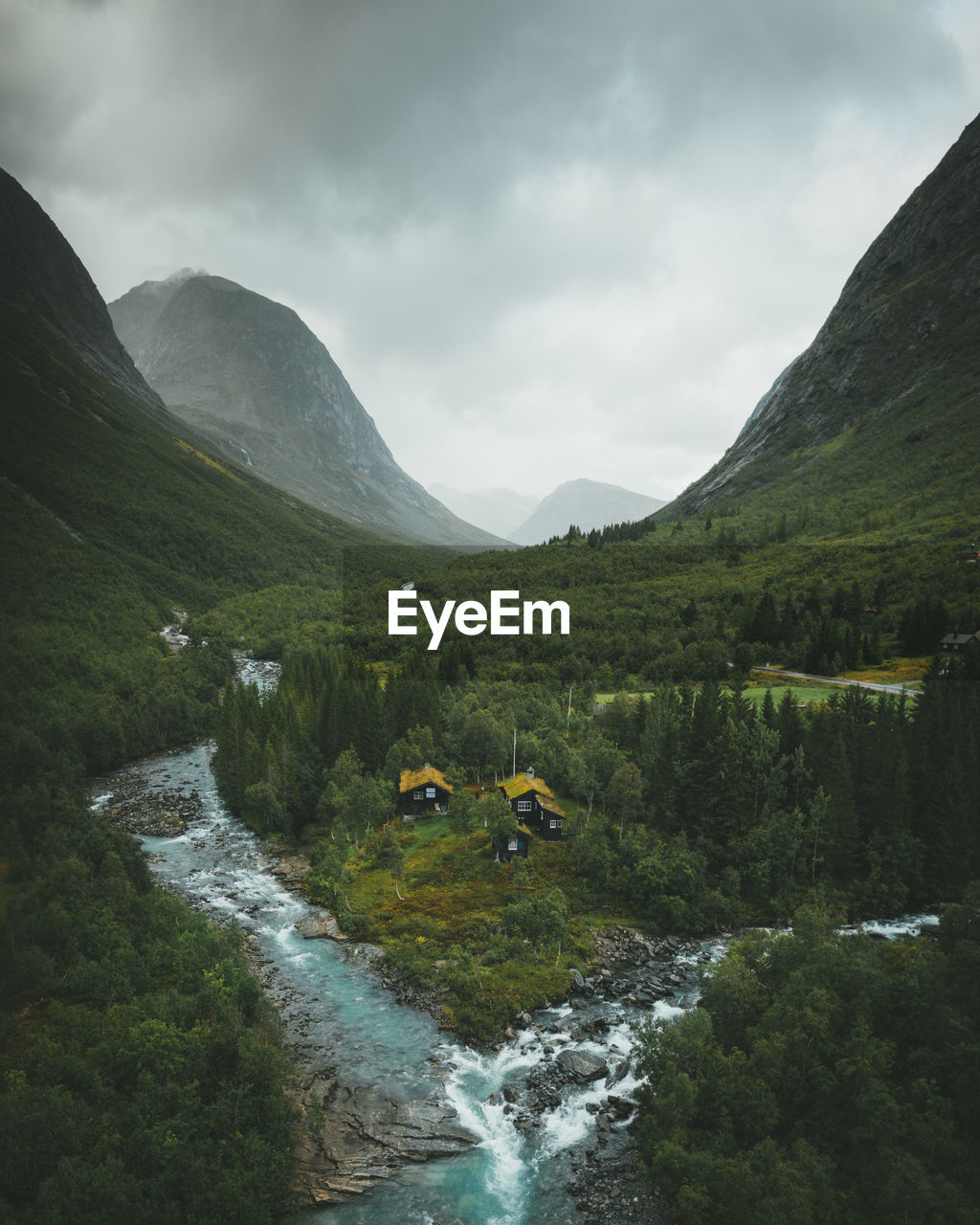 Scenic view of waterfall by mountains against sky