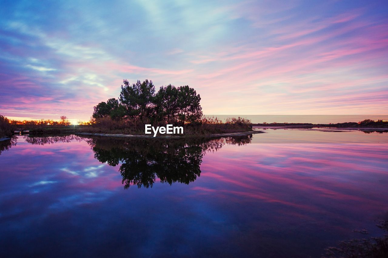 Scenic view of calm lake against cloudy sky