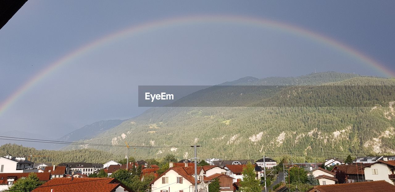 Scenic view of rainbow over town against sky