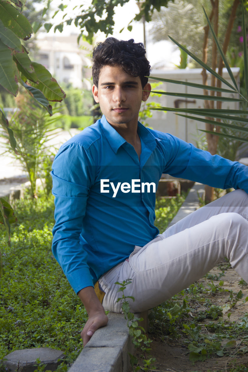 Portrait of young man sitting in park