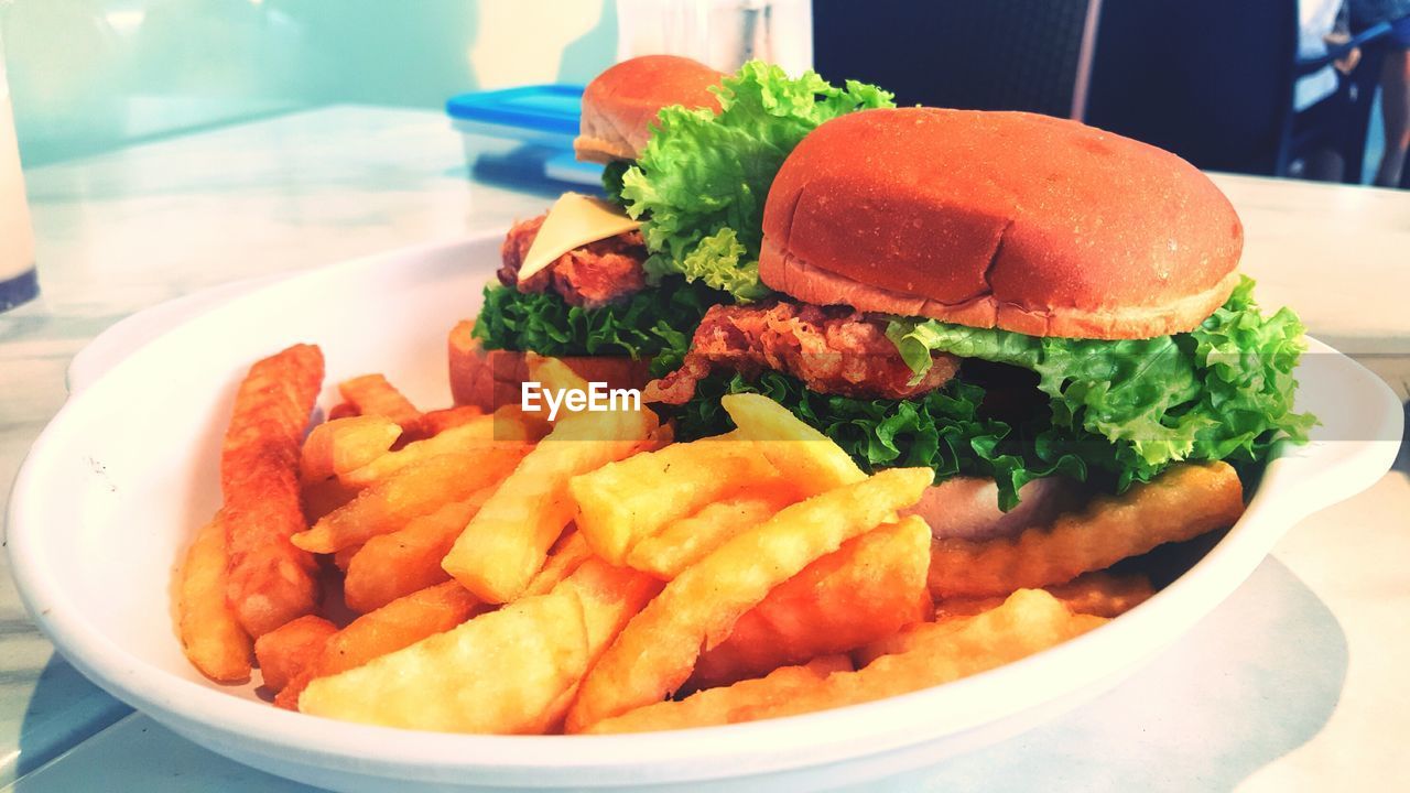 CLOSE-UP OF BURGER AND VEGETABLES ON PLATE