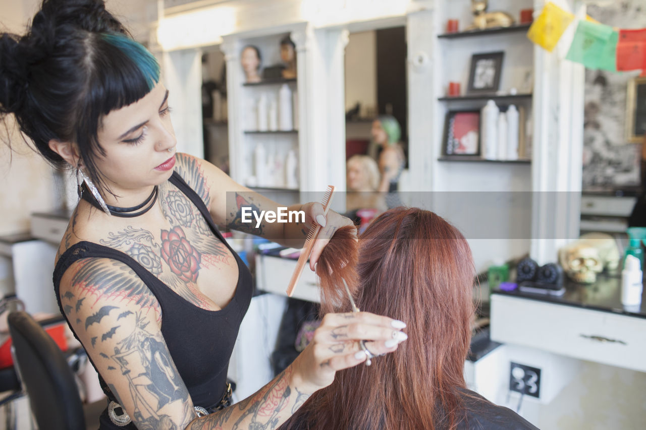 A hair dresser styling a customer's hair.