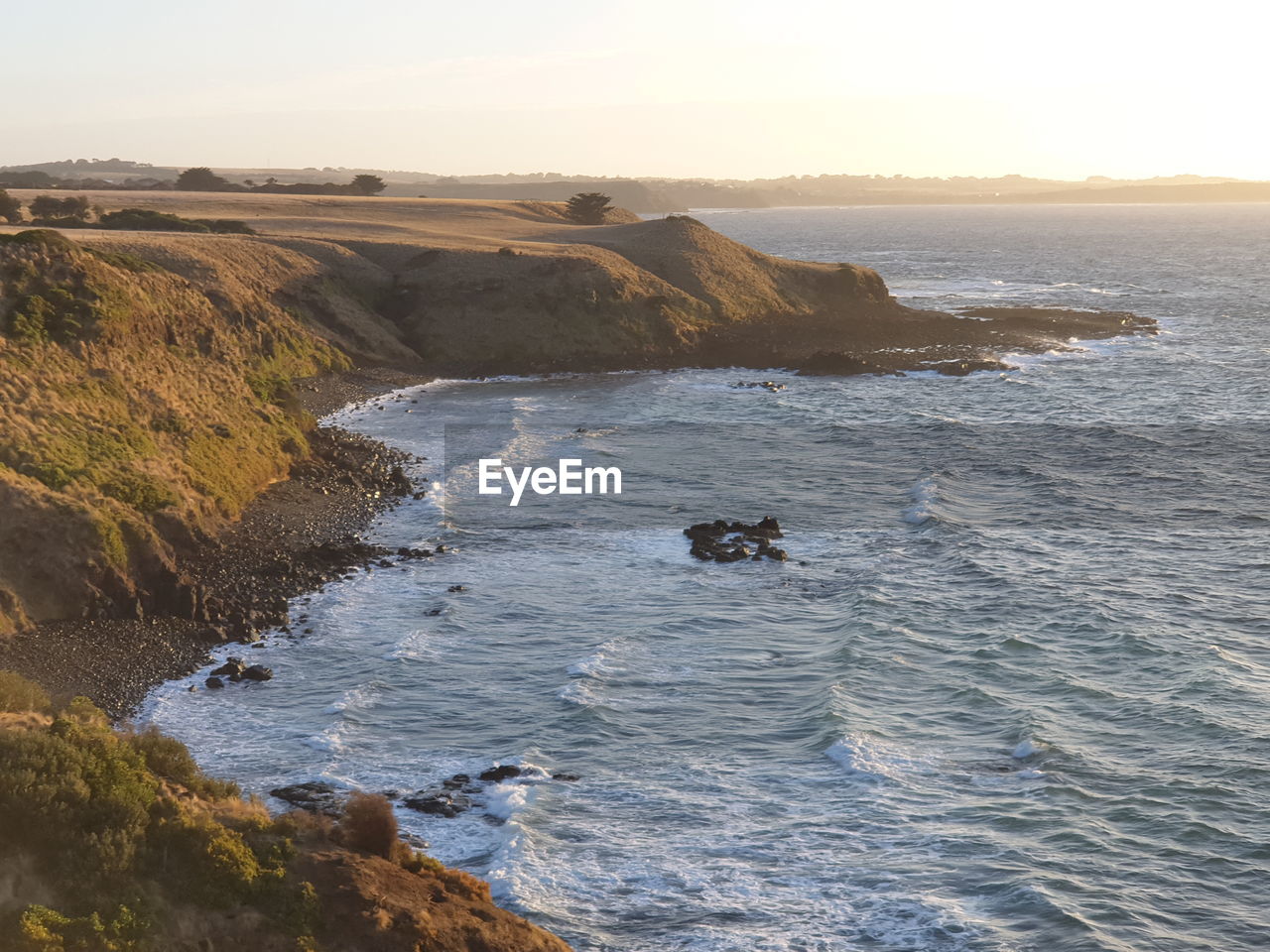 HIGH ANGLE VIEW OF SEA WAVES RUSHING TOWARDS SHORE