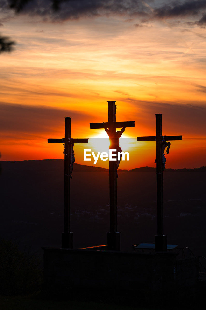 rear view of man standing by railing against sky during sunset