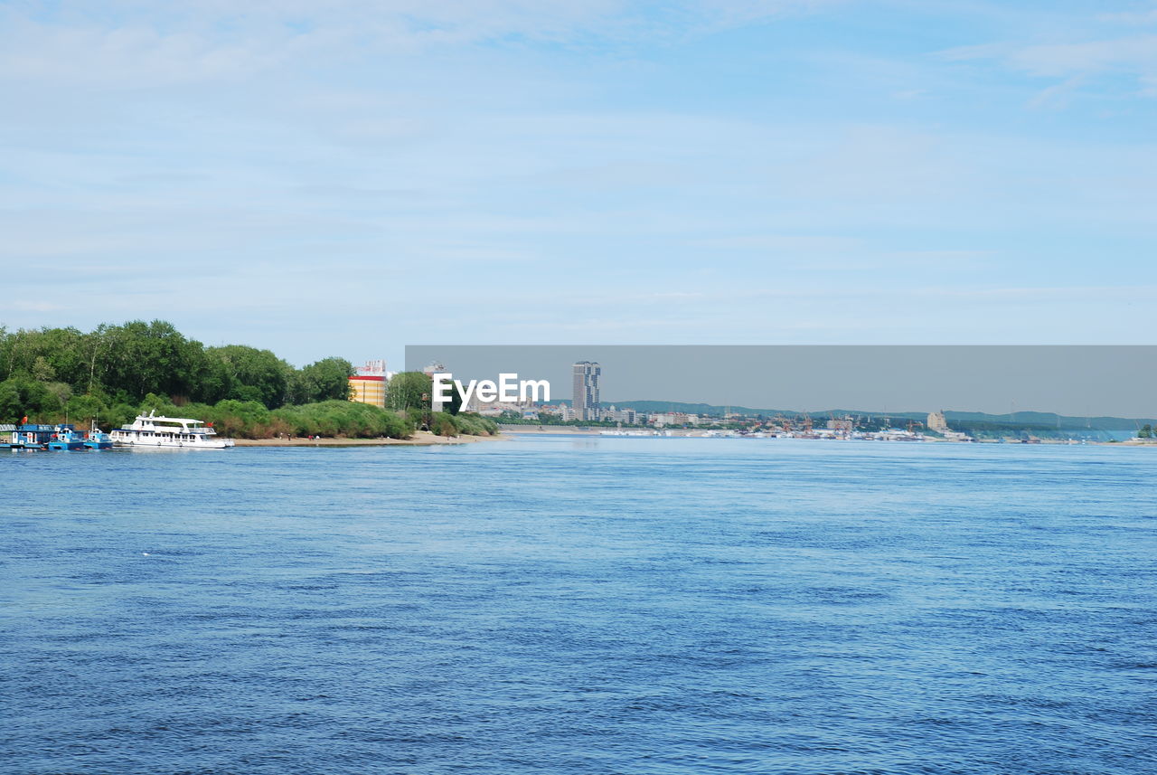 SCENIC VIEW OF SEA AGAINST BUILDINGS IN CITY