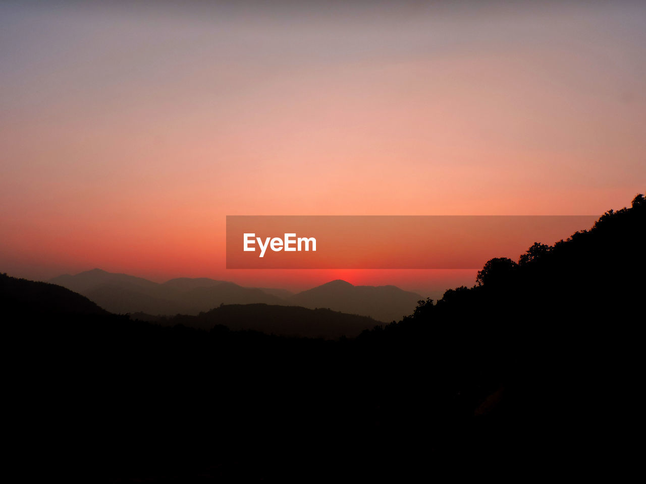 Scenic view of silhouette mountains against sky during sunset