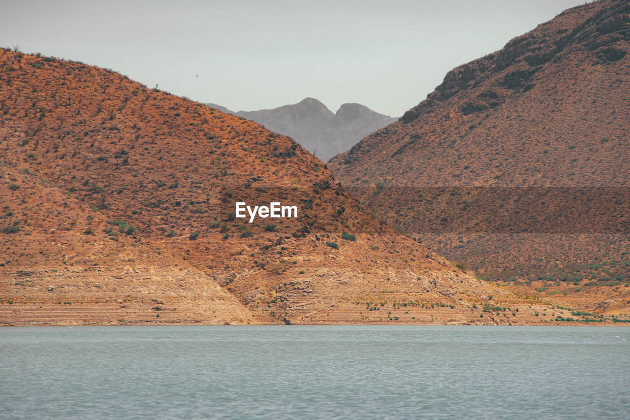 Scenic view of sea and mountains against sky