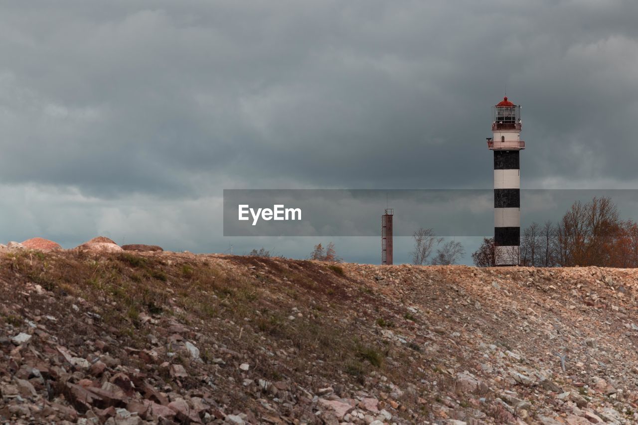 Lighthouse by sea against sky