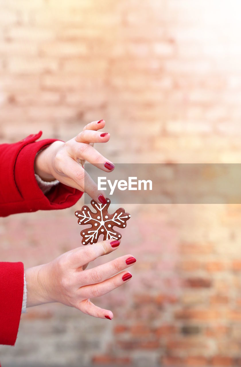 Cropped image of woman holding gingerbread cookie during christmas