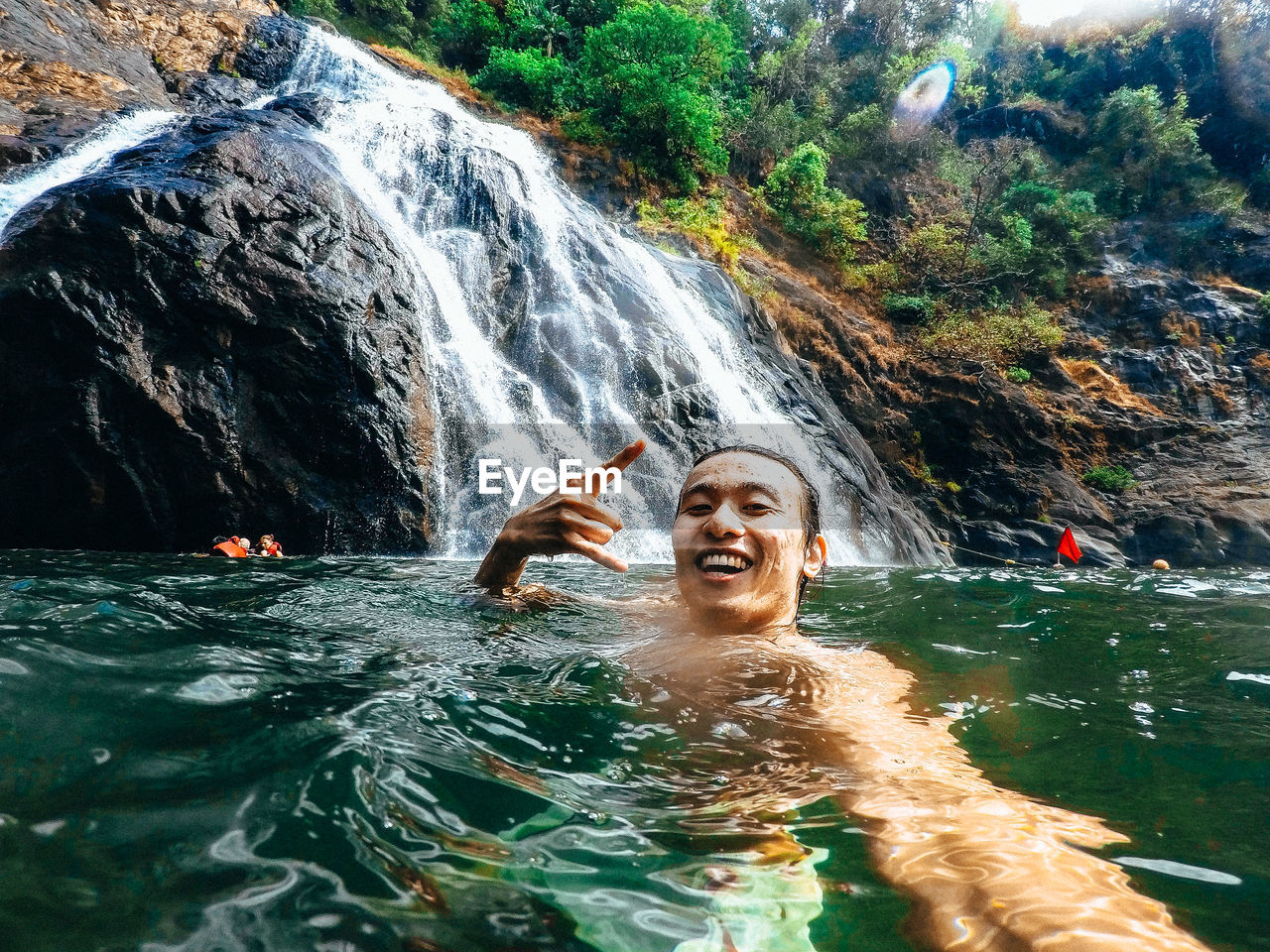 Portrait of people swimming in water at rock